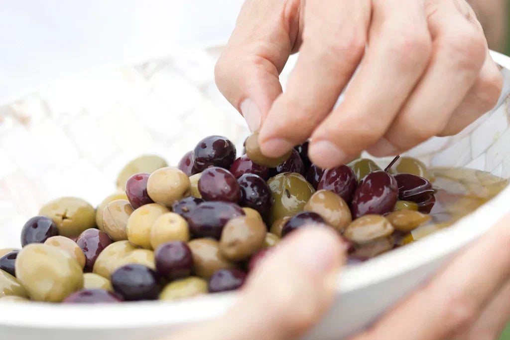 Kalamata und Grüne Oliven in einer Schale gehalten