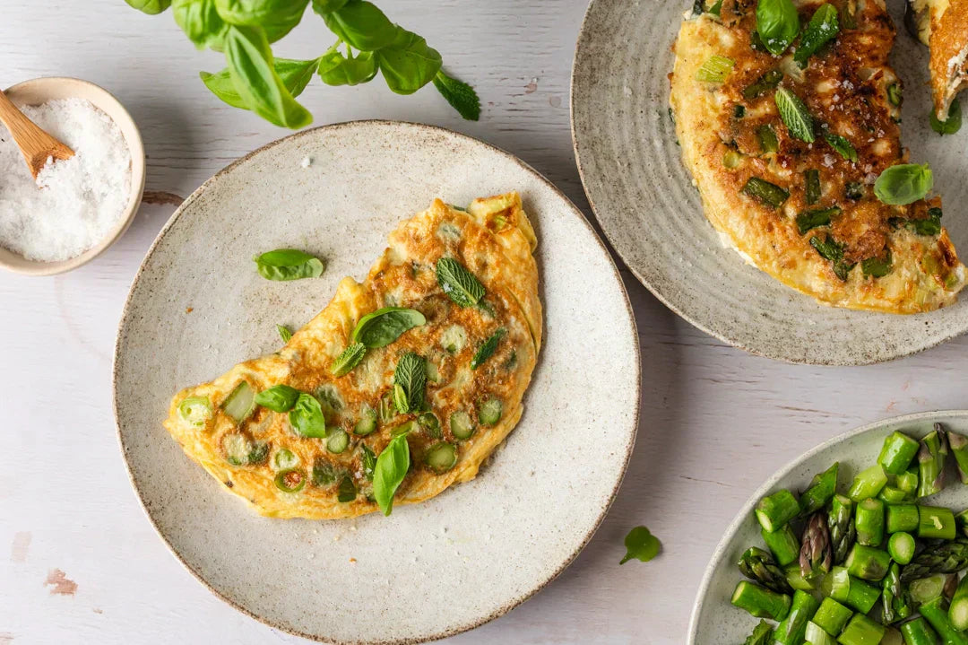 Spargel Omelette mit frischen Kräutern auf gedecktem Tisch