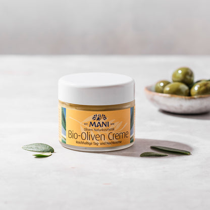 MANI Bio Olivencreme und Schälchen Oliven im Hintergrund