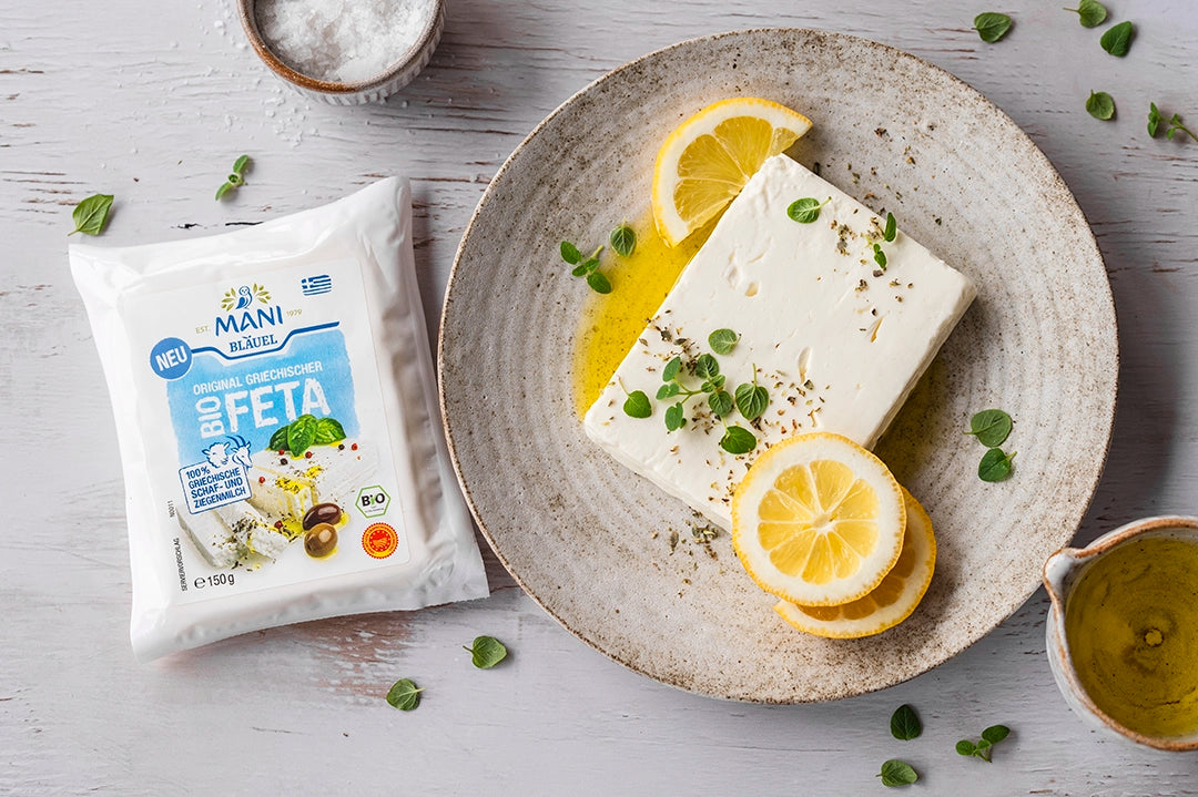 MANI Bläuel Bio-Feta g.U. auf Teller mit Zitronen und Kräutern
