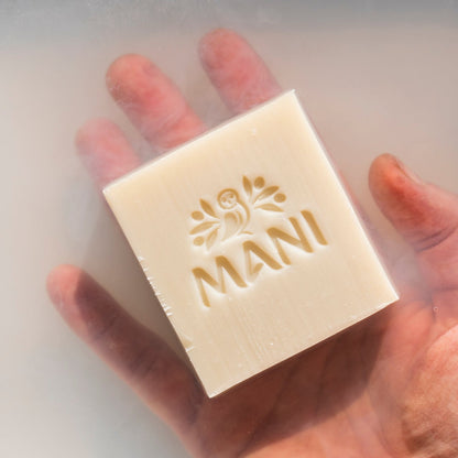 Mani Bio Oliven Seife von einer Hand im Wasser gehalten